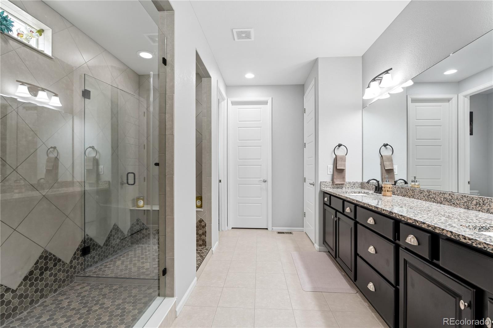 5740 Berry Ridge Wy. Castle Rock, CO 80104 - Photo 21 of 38 a spacious bathroom with a double vanity sink mirror and shower