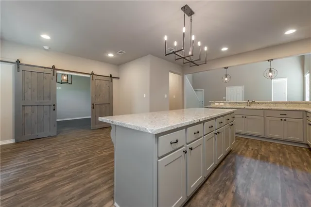 a kitchen with granite countertop a sink and a refrigerator