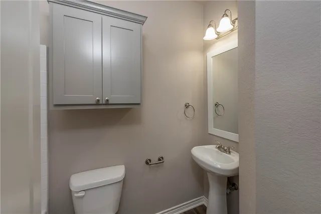 a bathroom with a sink a toilet and mirror