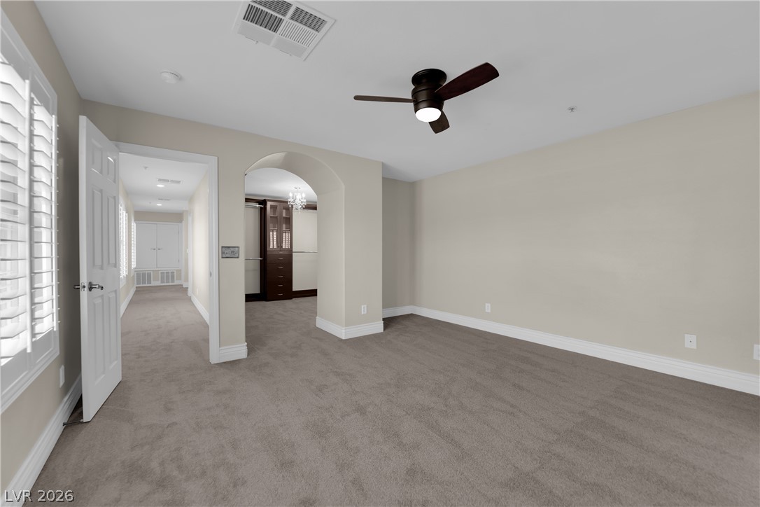 646 Monument Point Street Henderson, NV 89002 - Photo 22 of 44 A well-proportioned interior with plush carpeting and architectural arched doorways awaits.