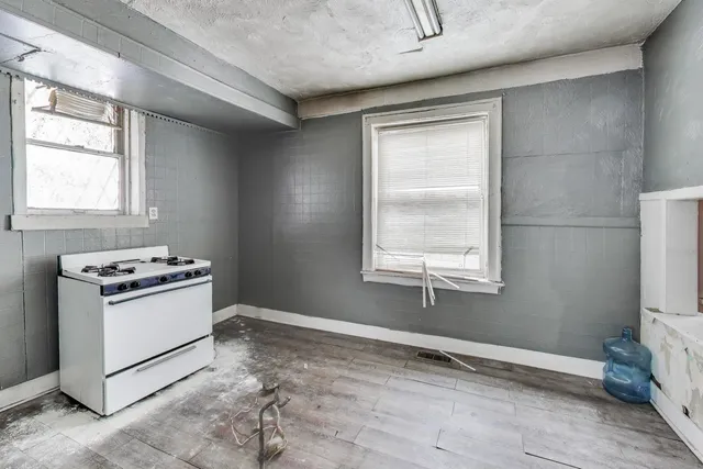 a kitchen with a stove a sink and a window