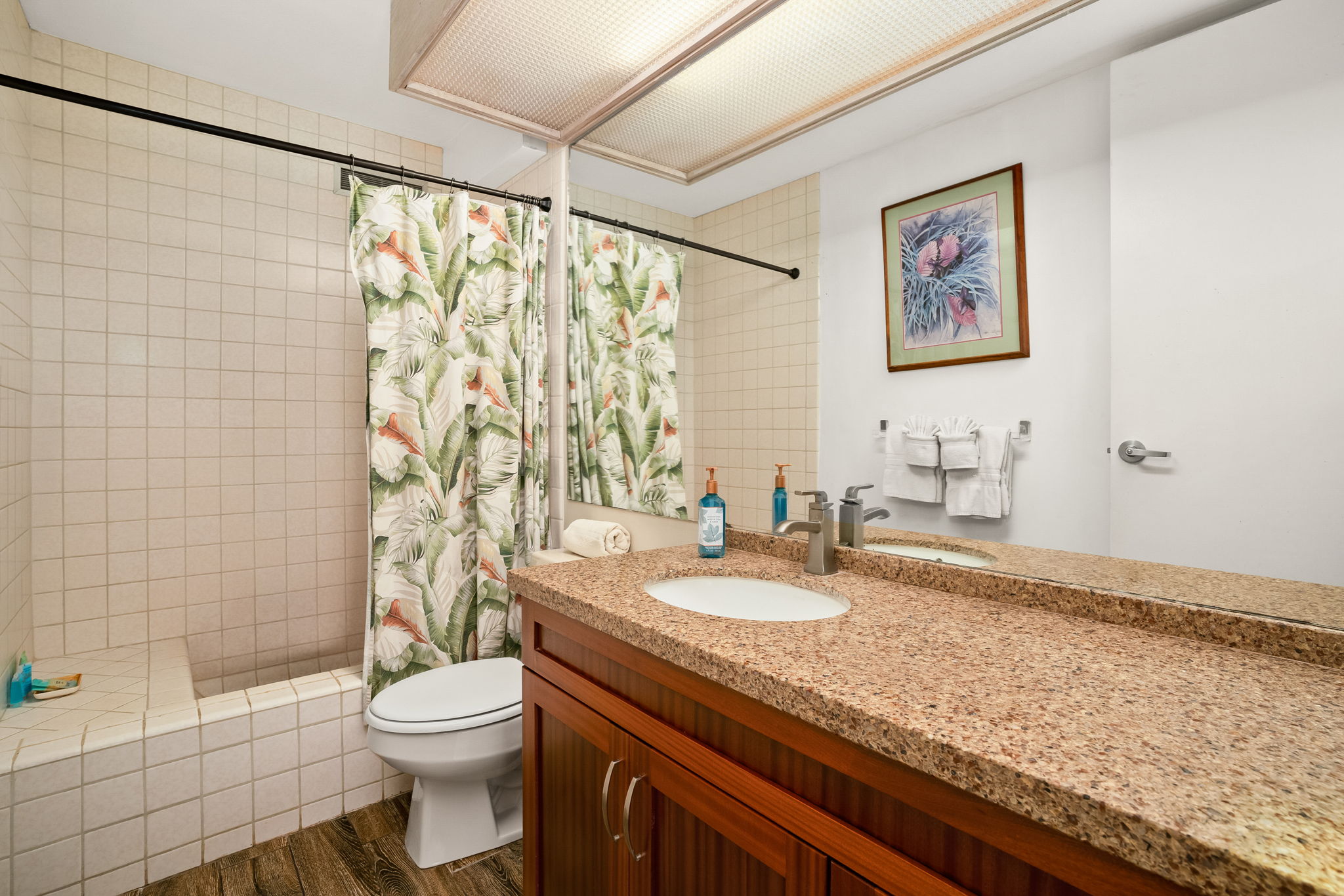 3811 Edward Road, Unit 8204 Princeville, HI 96722 - Photo 11 of 29 a bathroom with a granite countertop sink a toilet and shower