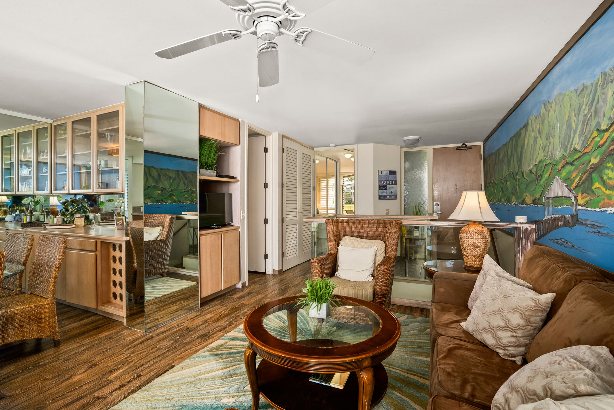 3811 Edward Road, Unit 8204 Princeville, HI 96722 - Photo 7 of 29 a living room with furniture a chandelier and a dining table with wooden floor