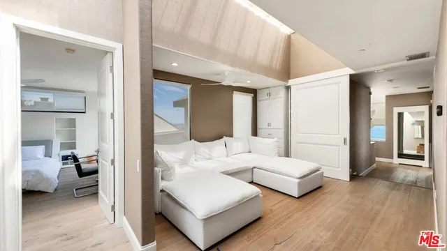 a living room with couches and a view of bedroom