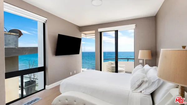a bedroom with a bed and a flat tv screen next to a window