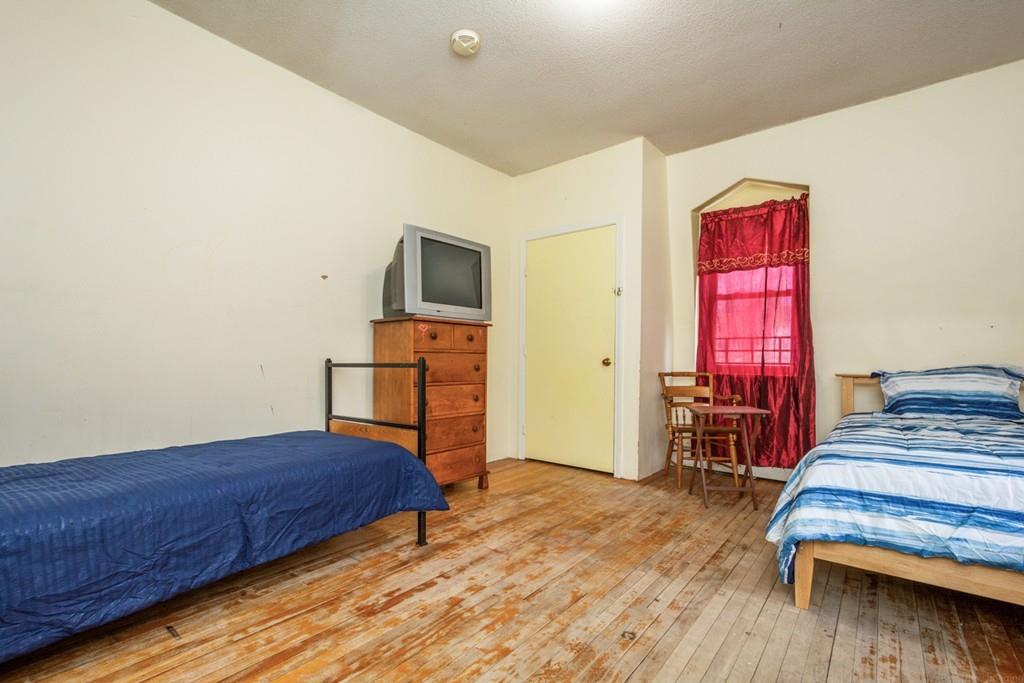 67 Congress Street Fitchburg, MA 01420 - Photo 27 of 39 a bedroom with a bed a dresser and wooden floor