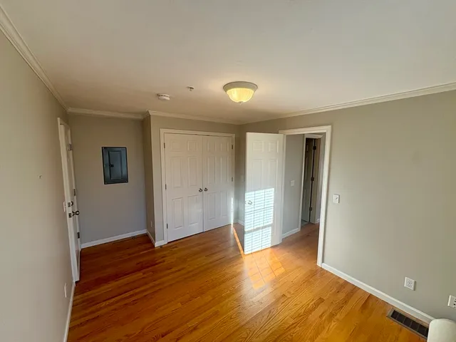 a view of an empty room with wooden floor