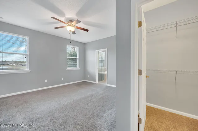 a view of an empty room and a ceiling fan