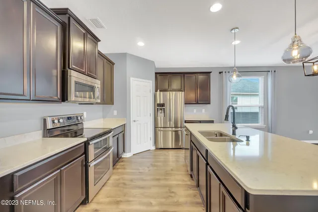 a kitchen with stainless steel appliances granite countertop a sink stove and refrigerator