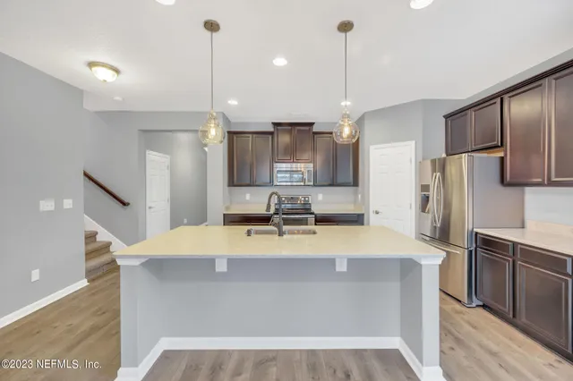 a large kitchen with kitchen island a sink stainless steel appliances and cabinets