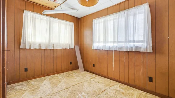 a view of an empty room with window and hardwood floor