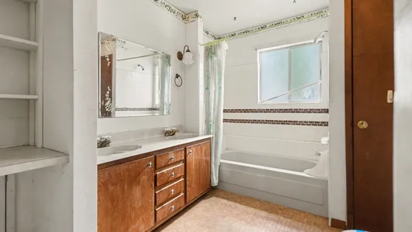 a bathroom with a tub sink and mirror