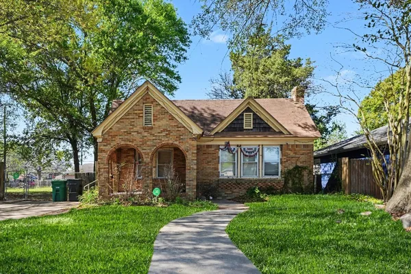 a front view of a house with a garden and plants
