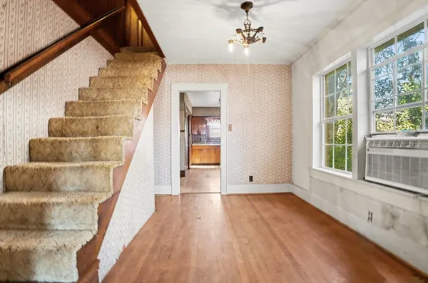 a view of an entryway with wooden floor and cabinet
