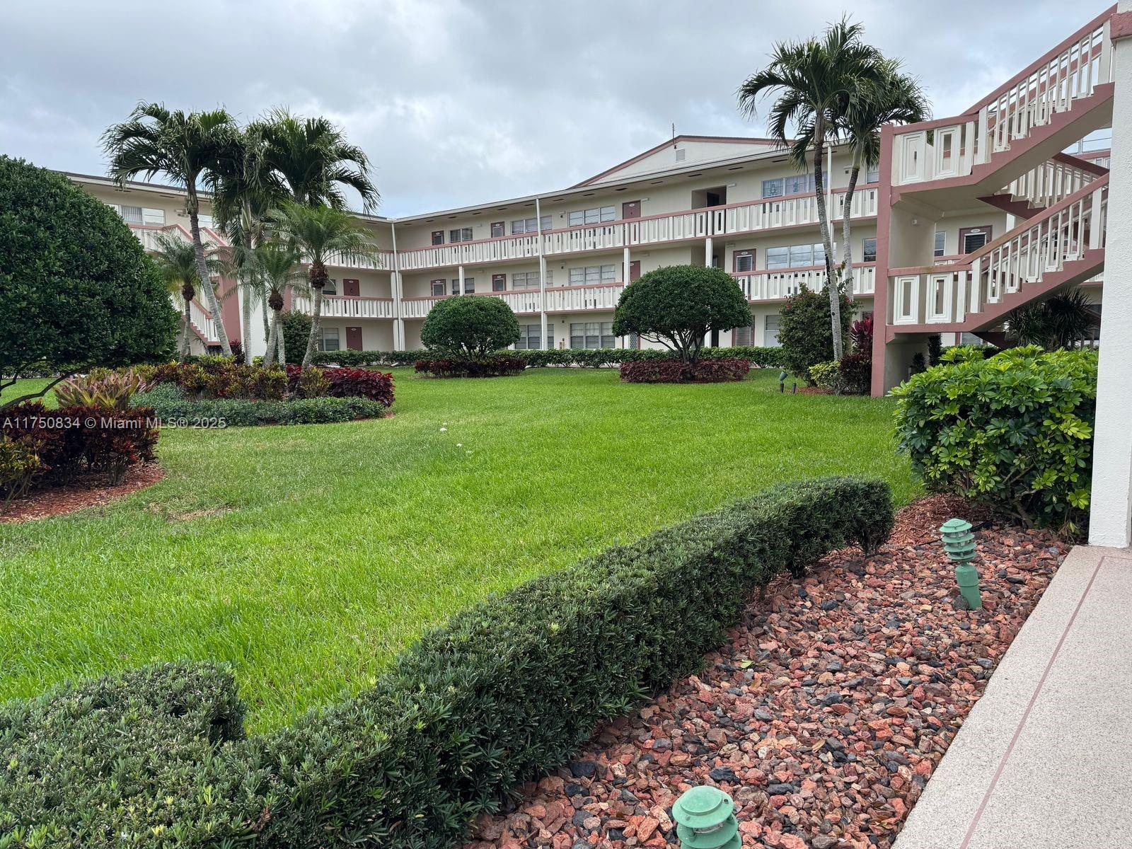 310 Preston H, Unit 310 Boca Raton, FL 33434 - Photo 1 of 21 a front view of a house with a garden and plants