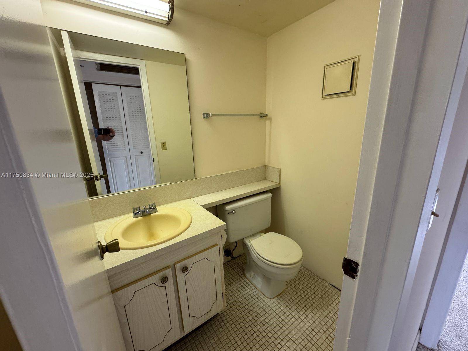 310 Preston H, Unit 310 Boca Raton, FL 33434 - Photo 12 of 21 a bathroom with a granite countertop sink toilet and mirror