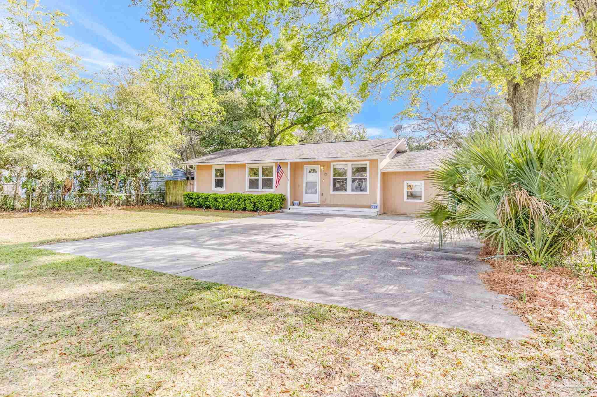 a front view of a house with a yard and trees