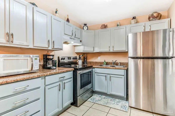 a kitchen with granite countertop white cabinets and white appliances