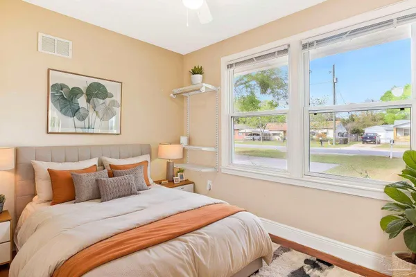 a bedroom with a bed and a painting on the wall