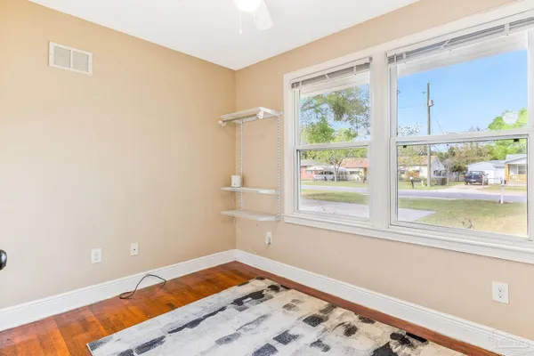 a view of a bedroom with wooden floor and a window