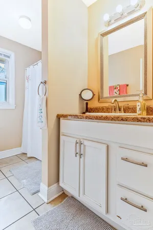 a bathroom with a granite countertop sink and a mirror