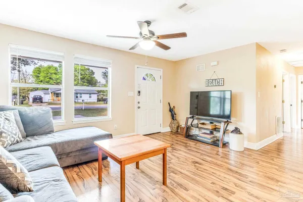 a living room with furniture a flat screen tv and a table