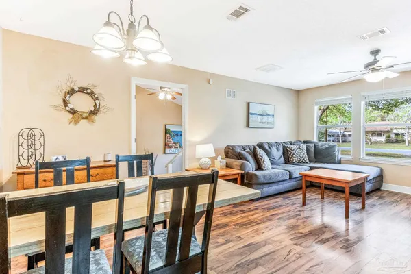 a living room with furniture a chandelier and a dining table