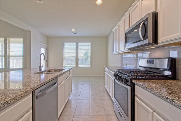 a kitchen with stainless steel appliances granite countertop a stove and a sink