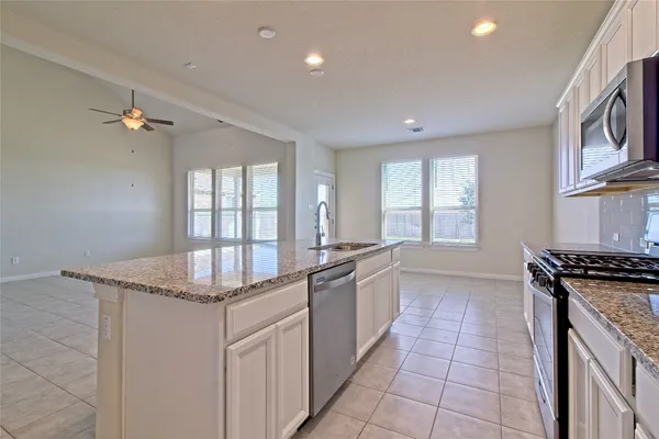 a kitchen with stainless steel appliances granite countertop a sink and a stove