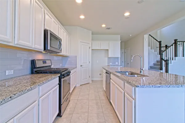 a kitchen with stainless steel appliances granite countertop a stove and a sink
