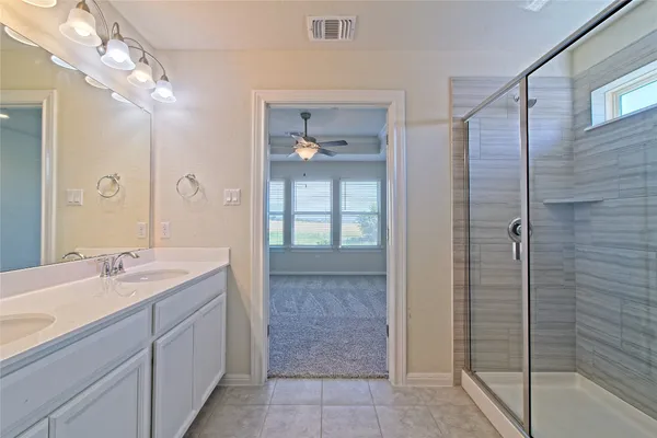 a bathroom with a double vanity sink a mirror and a shower