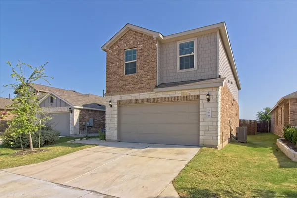a front view of a house with a yard and garage