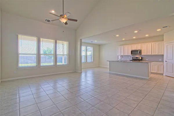 a view of an empty room with kitchen appliances and a cabinets