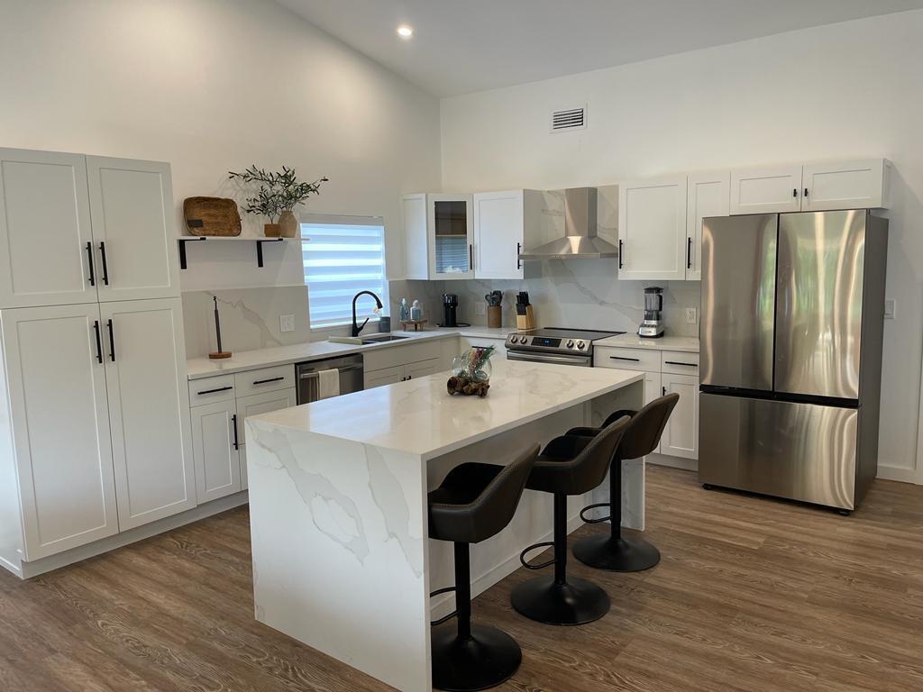 7360 San Sebastian Drive Boca Raton, FL 33433 - Photo 7 of 27 a kitchen with refrigerator and chairs