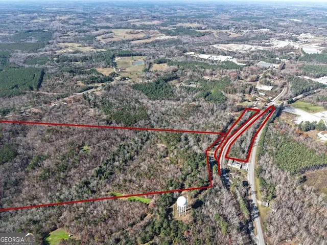an aerial view of a house with a yard and mountain view in back