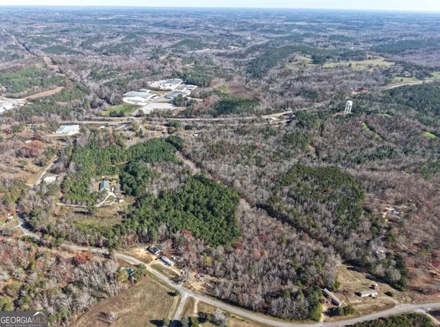 an aerial view of residential houses with outdoor space and trees