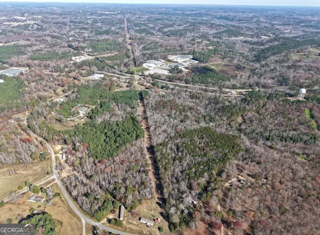 an aerial view of residential houses with outdoor space and trees
