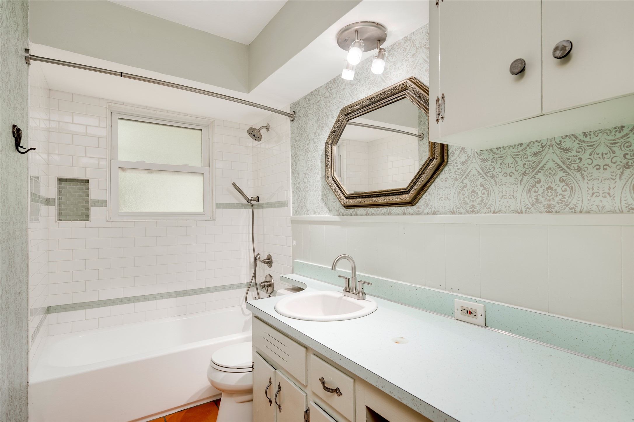 1707 Overhill Drive Austin, TX 78721 - Photo 11 of 36 A compact bath featuring a tub and shower combination, complemented by a simple vanity and mirror.