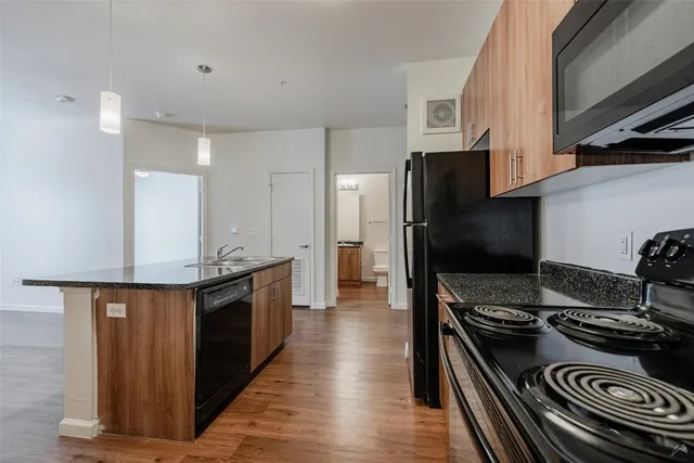 a view of a kitchen with wooden floor and refrigerator