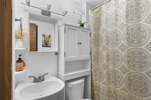 a bathroom with a sink and mirror with toilet