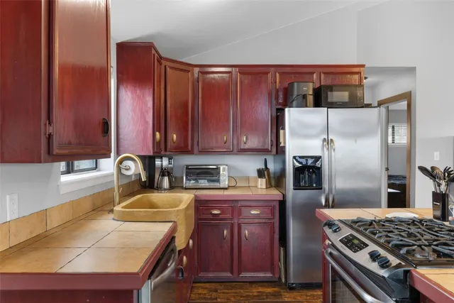 a kitchen with stainless steel appliances granite countertop a refrigerator stove and sink