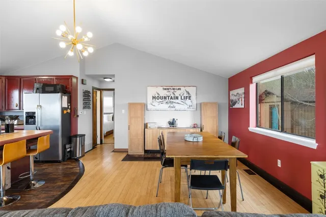 a view of a dining room with furniture a chandelier and wooden floor