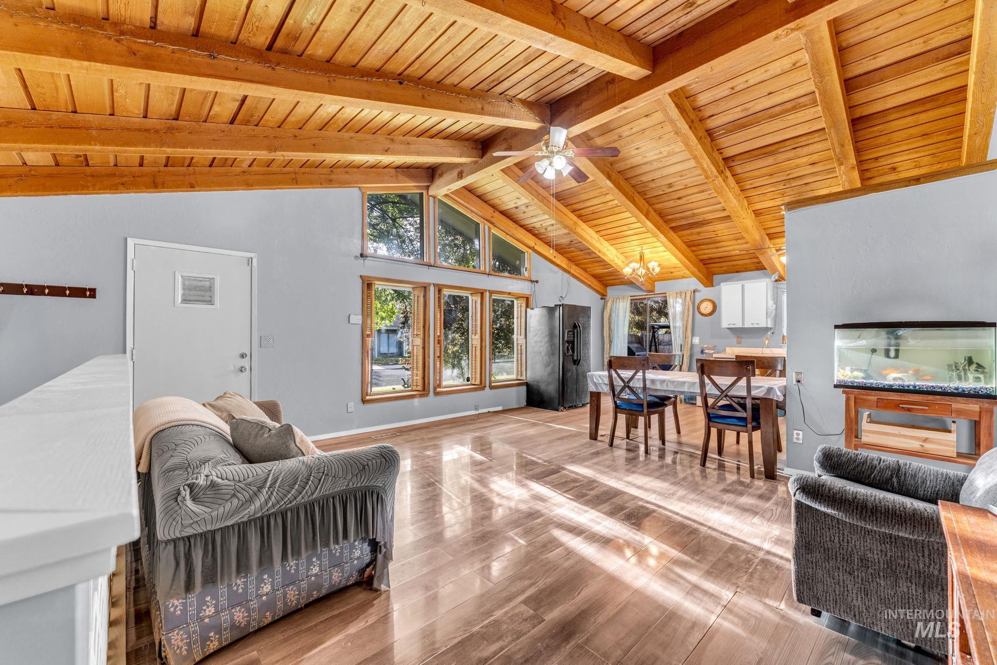 820 Meadows Drive Twin Falls, ID 83301 - Photo 5 of 38 Open-concept living area featuring a vaulted wood-paneled ceiling, exposed wood beams, and expansive windows
