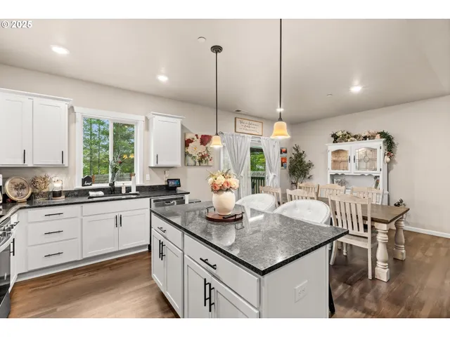 a kitchen with granite countertop kitchen island stainless steel appliances a table and sink
