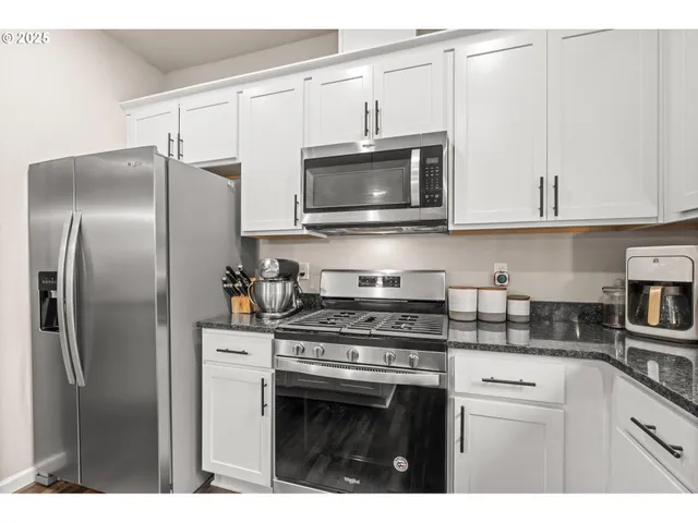 a kitchen with cabinets stainless steel appliances and a sink