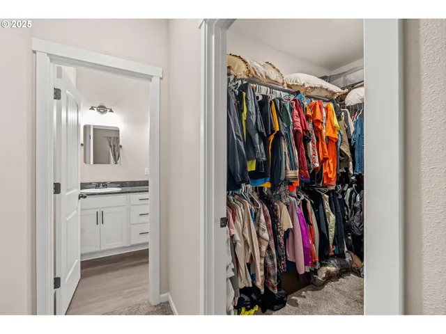 a view of walk in closet with clothes