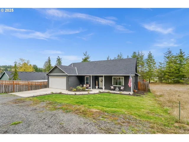 a view of a house with a big yard and large tree