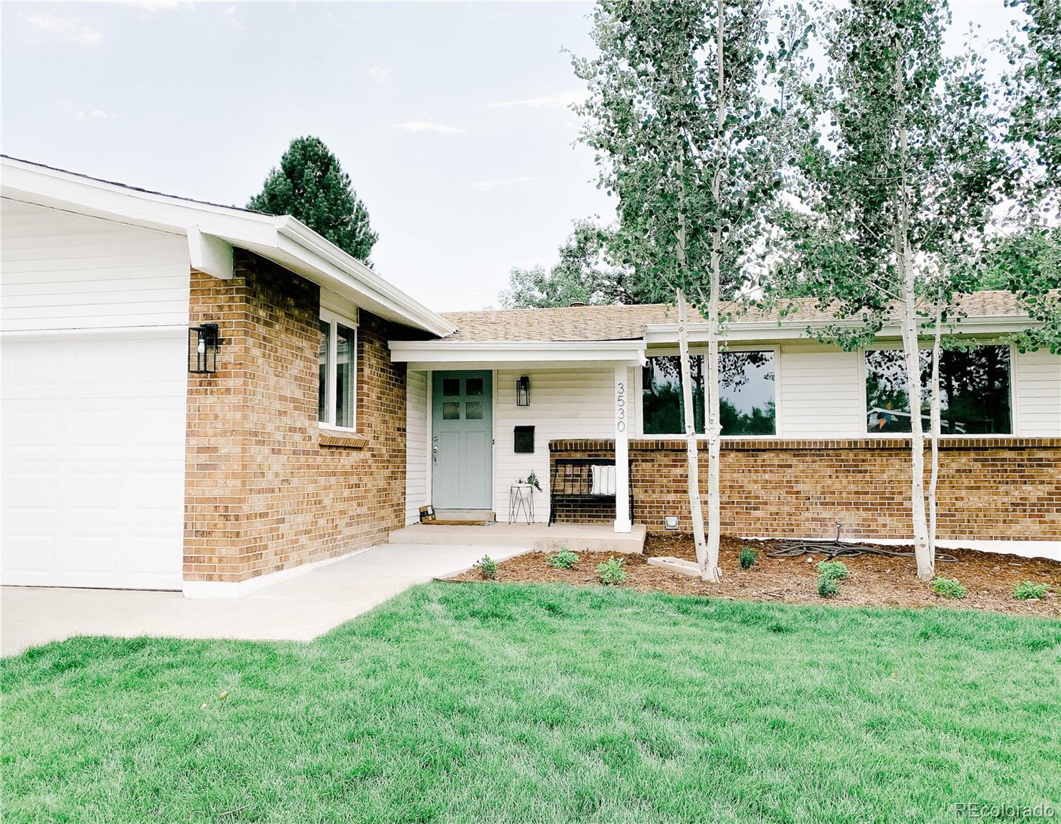 a view of a house with a yard and sitting area