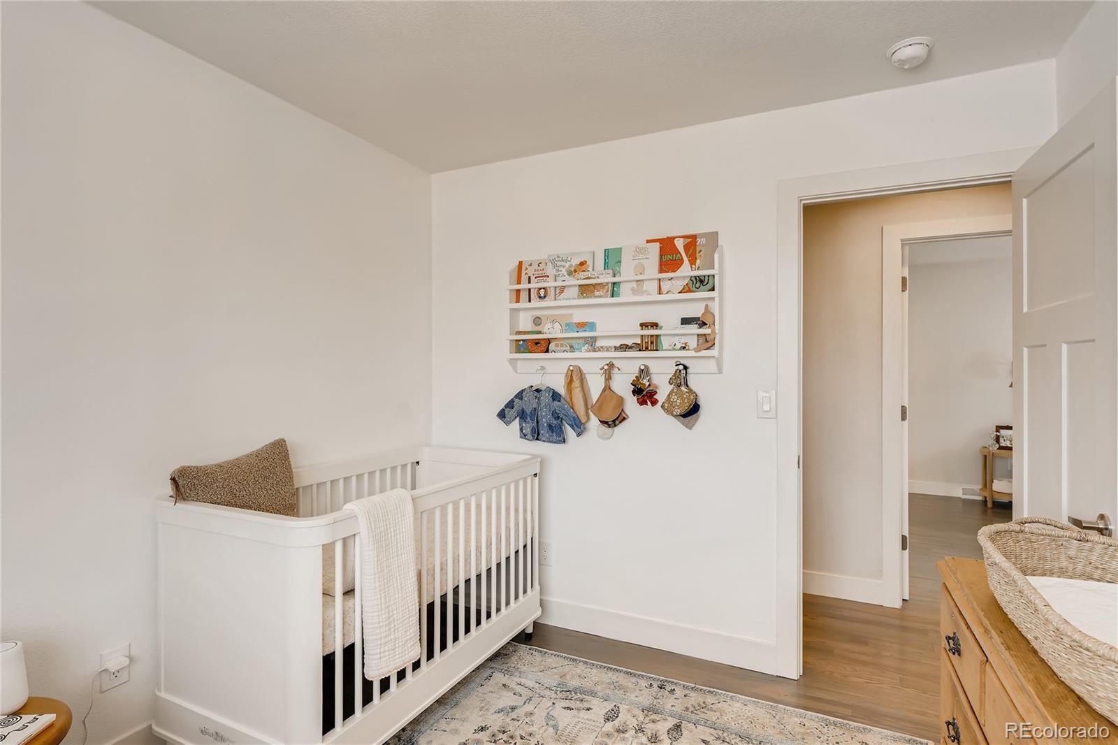3530 East Orchard Road Centennial, CO 80121 - Photo 19 of 35 a view of a hallway to a livingroom with wooden floor and windows