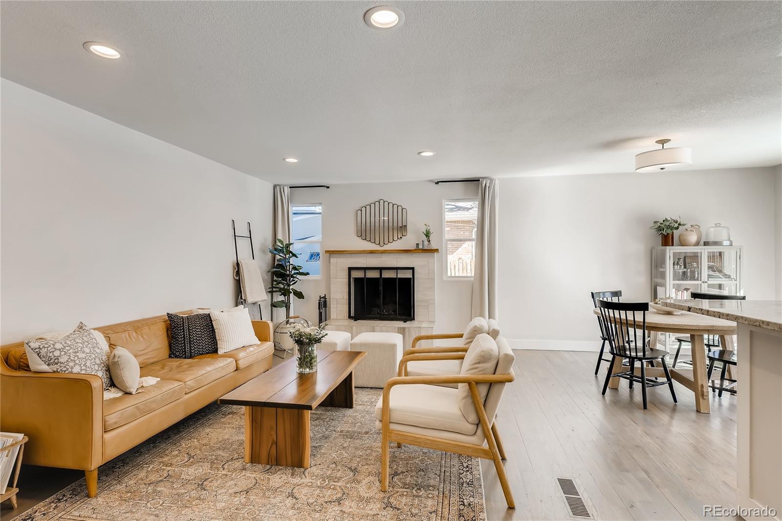 3530 East Orchard Road Centennial, CO 80121 - Photo 5 of 35 a living room with furniture a table and a fireplace